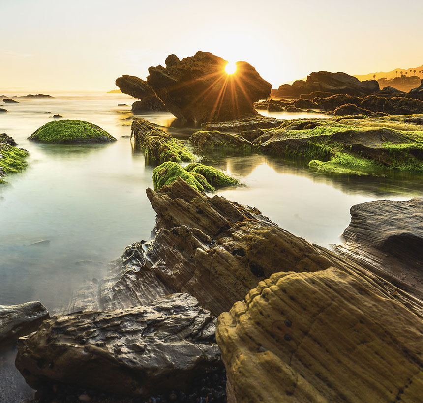 sunset over a rocky misty lagoon